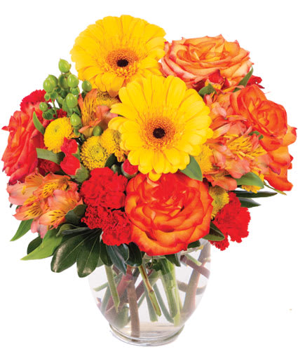 Bouquet of yellow gerbera daisies and orange roses in a clear glass vase