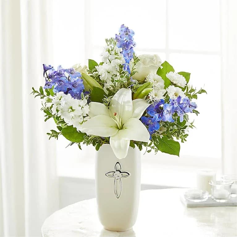 Heavens Blooms Bouquet - Heavens blooms indeed, this bouquet makes a beautiful gift to offer condolences or to honor a religious holiday. Florals this beautiful arrangement contains are delphinium, roses, stock, and lilies. For long–lasting blooms, replace the water daily. We suggest trimming the stems every couple days.  Please note the bouquet pictured reflects our original design.  If the exact flowers or container in this arrangement are not available, we will sub for the freshest available flowers equal to or greater in value and closest available container.