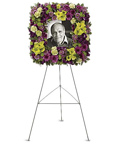 Picture of Memories Square Spray - This stunning square easel wreath of purple and green flowers is a beautiful and unusual tribute to a special person whose life has brought joy to so many. The elegant arrangement includes purple alstroemeria, green gladioli, green carnations, purple cushion spray chrysanthemums, lavender button spray chrysanthemums, green button spray chrysanthemums and purple button spray chrysanthemums, accented with assorted greenery.  We can make this in an array of colors. If your wanting specific colors please call our shop to verify our floral availability.  Please note the bouquet pictured reflects our original design.  If the exact flowers in this arrangement are not available, we will sub for the freshest available flowers equal to or greater in value.