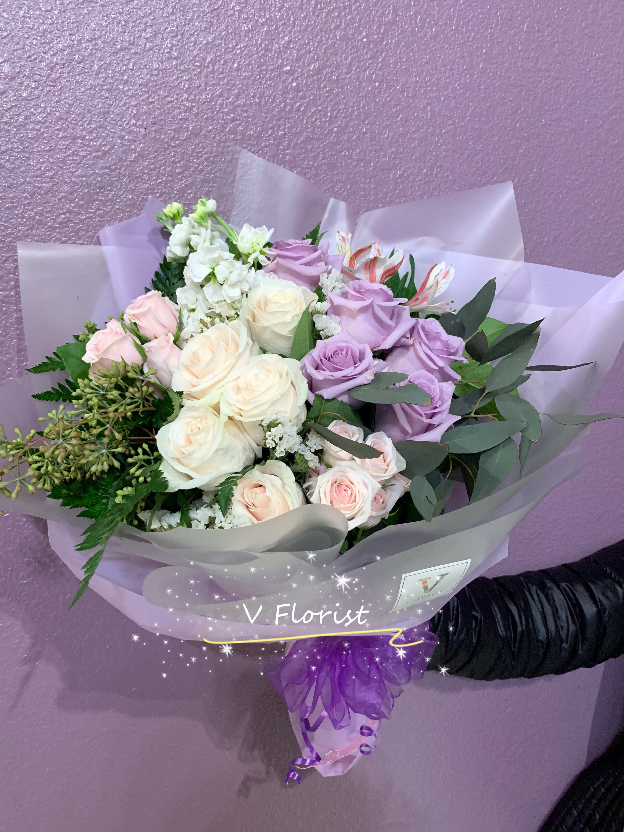 Bouquet of lavender and cream roses with pink flowers in purple wrap