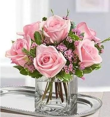Pink roses arranged in a clear glass vase