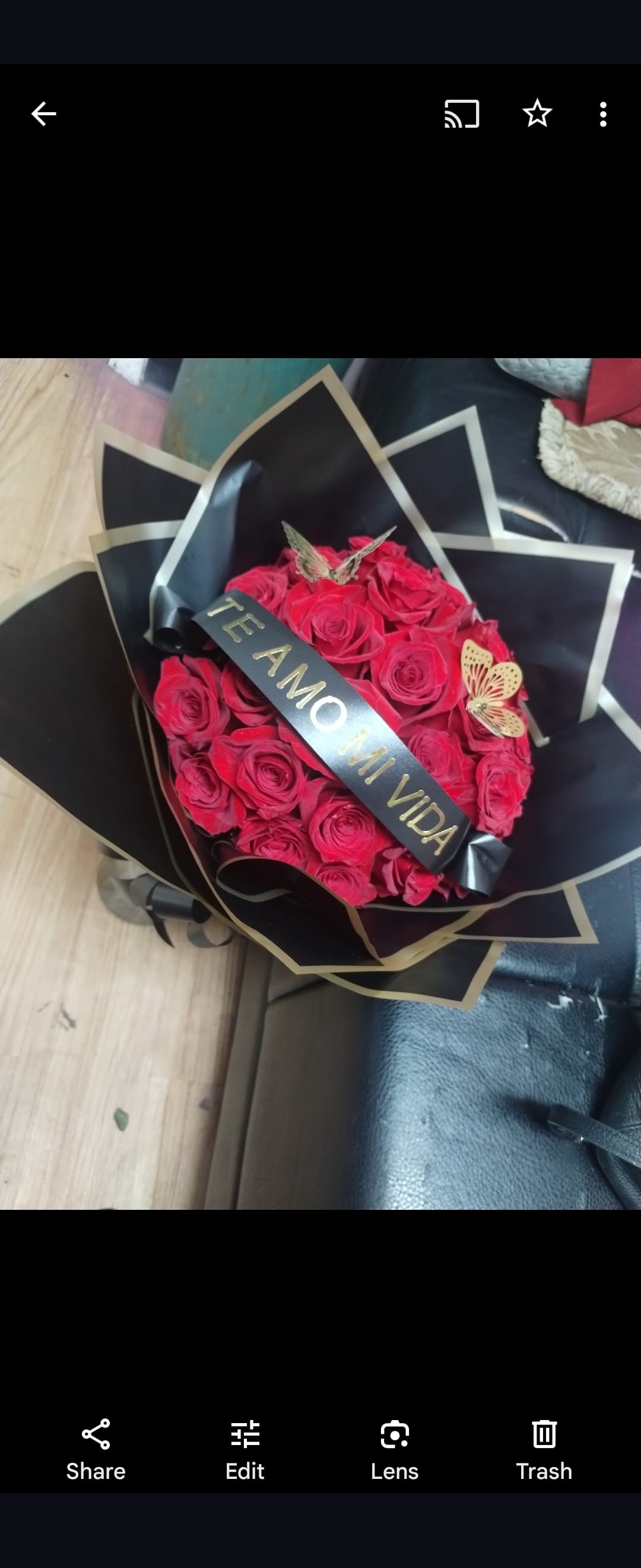 Bouquet of red roses wrapped in black paper with a ribbon