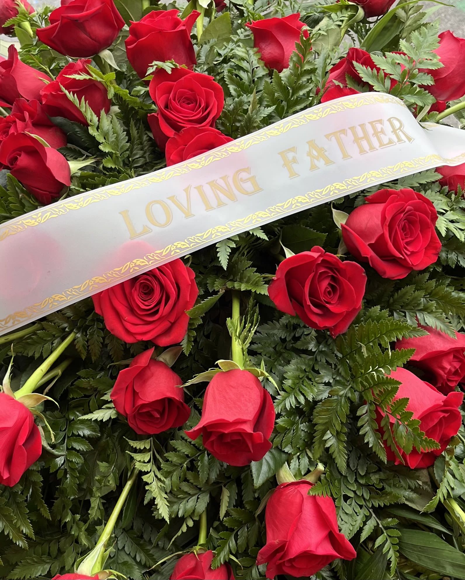 Red roses with a "Loving Father" ribbon