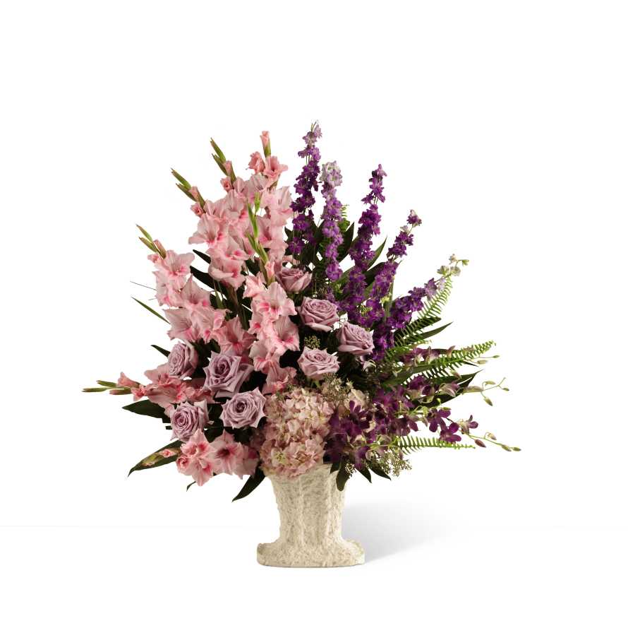 Pink and purple floral arrangement in a textured pedestal vase