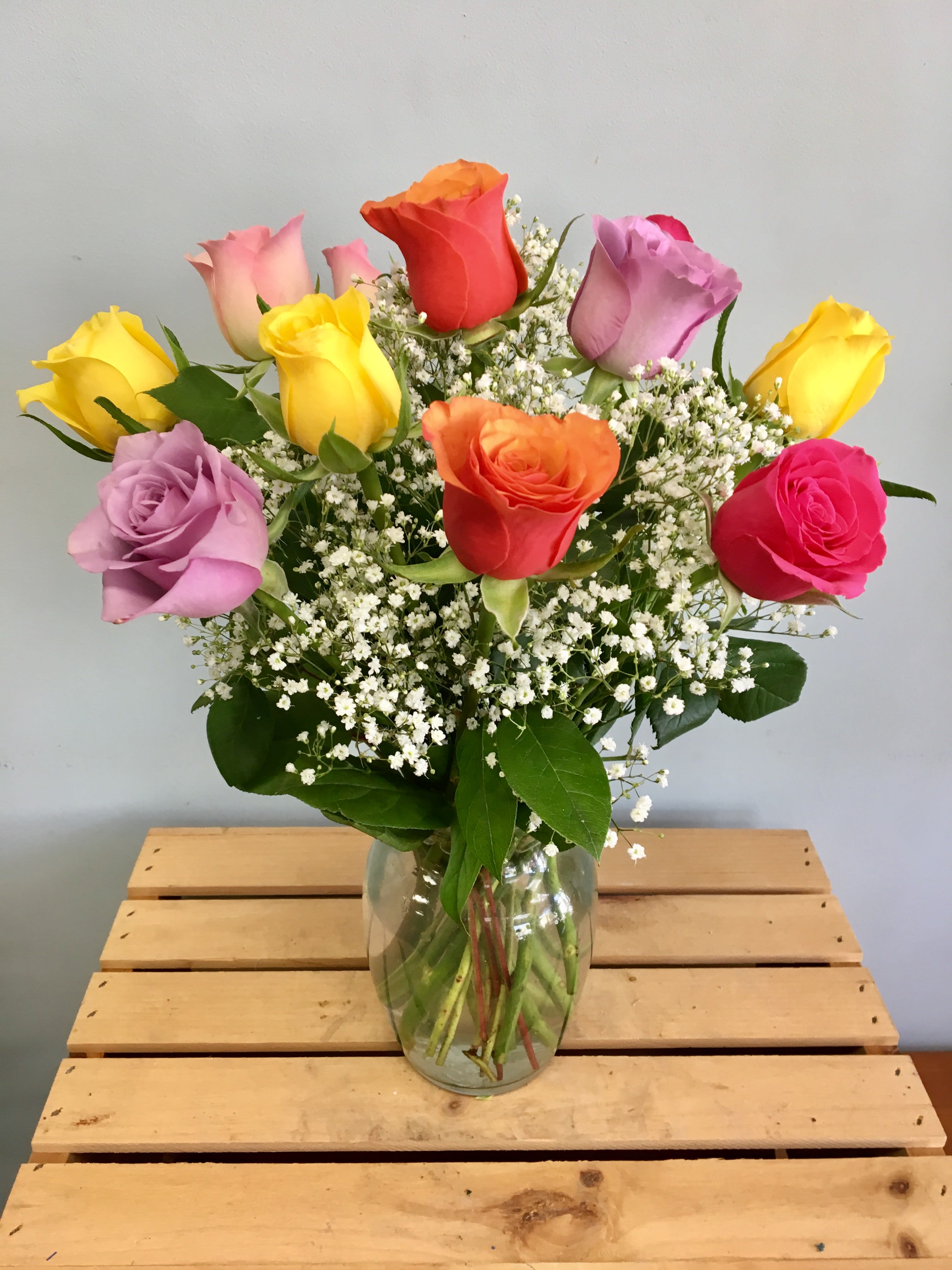 Colorful roses arranged in a clear glass vase