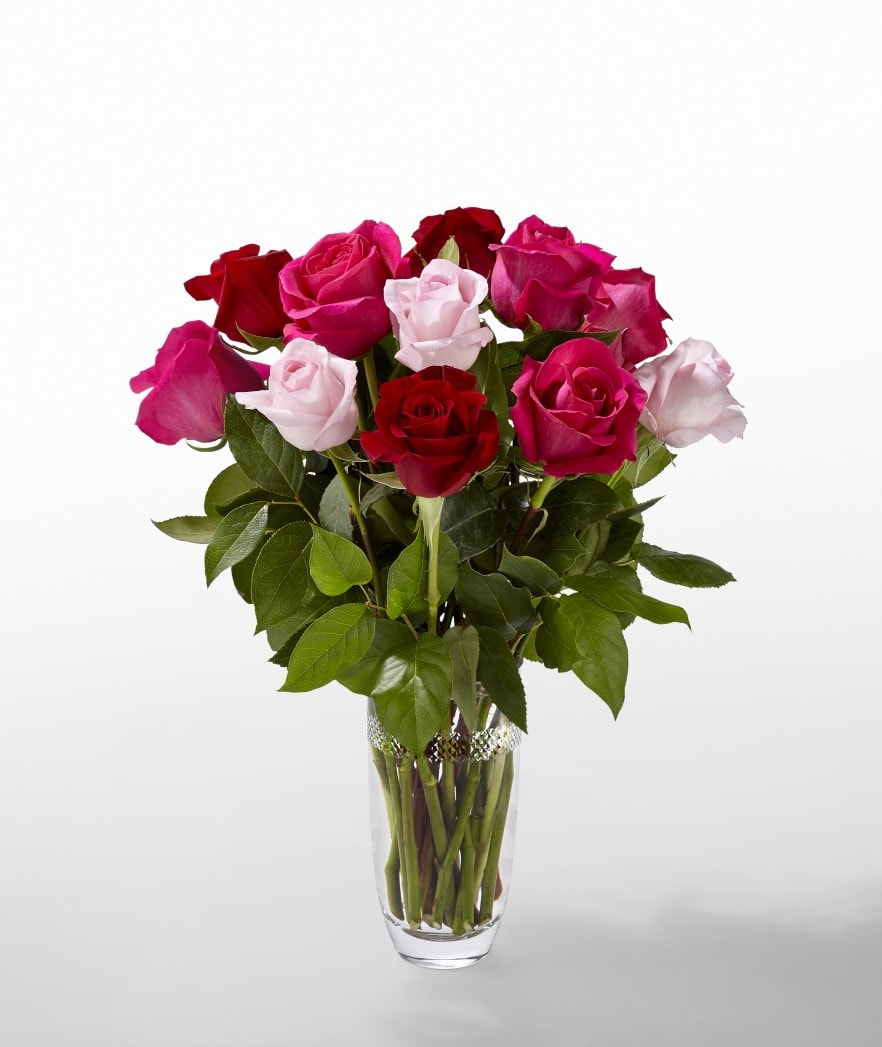 Bouquet of red, pink, and pale pink roses in a clear glass vase