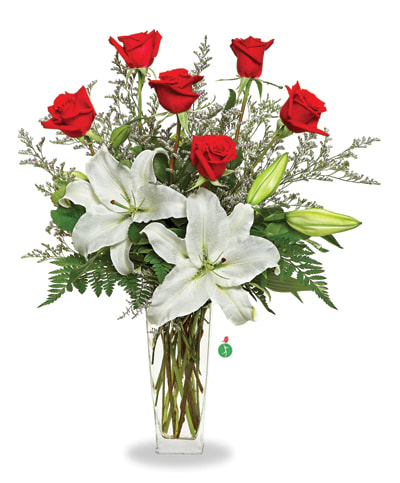 Red roses and white lilies arranged in a clear glass vase