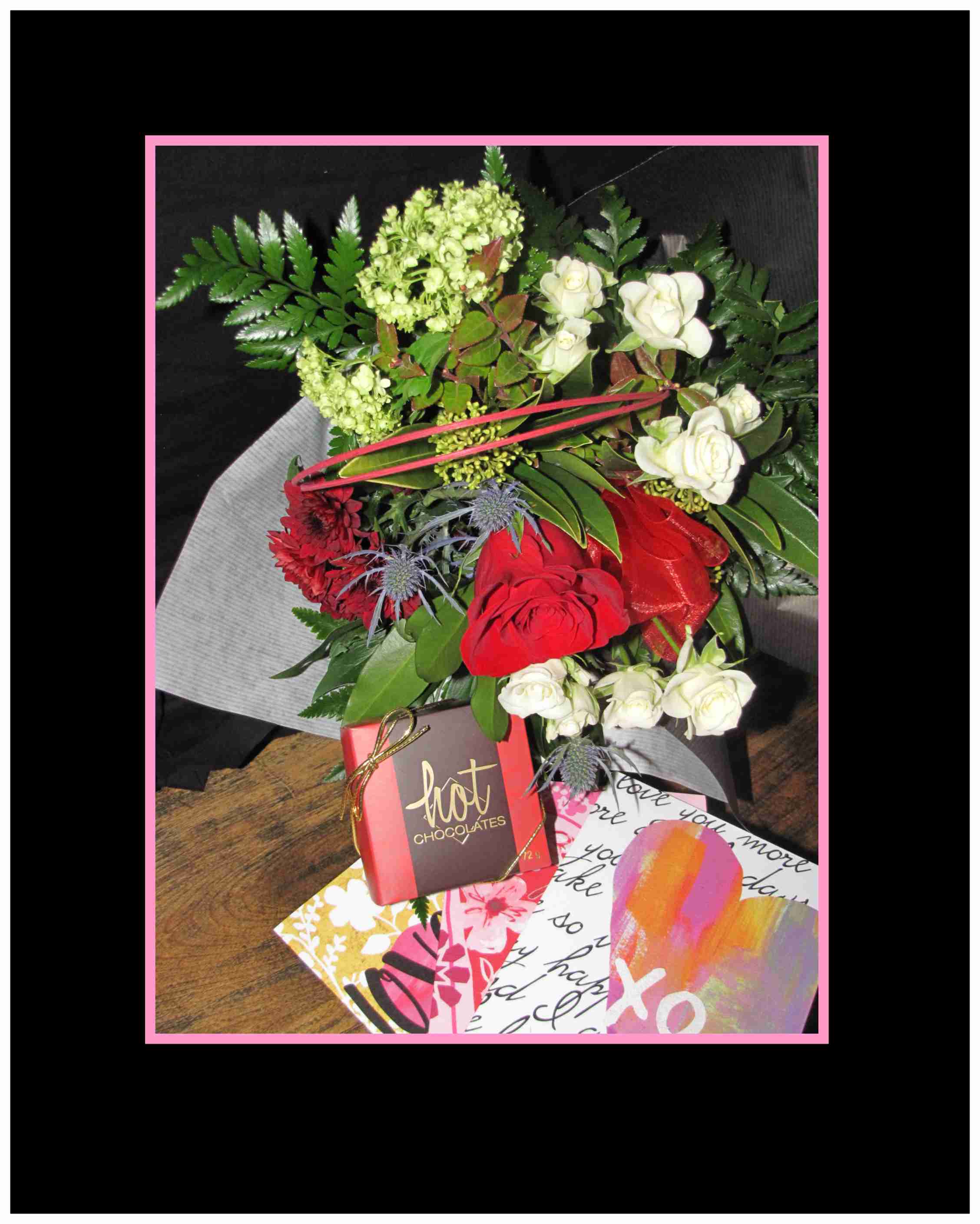 Bouquet of red and white flowers with a chocolate box and greeting cards