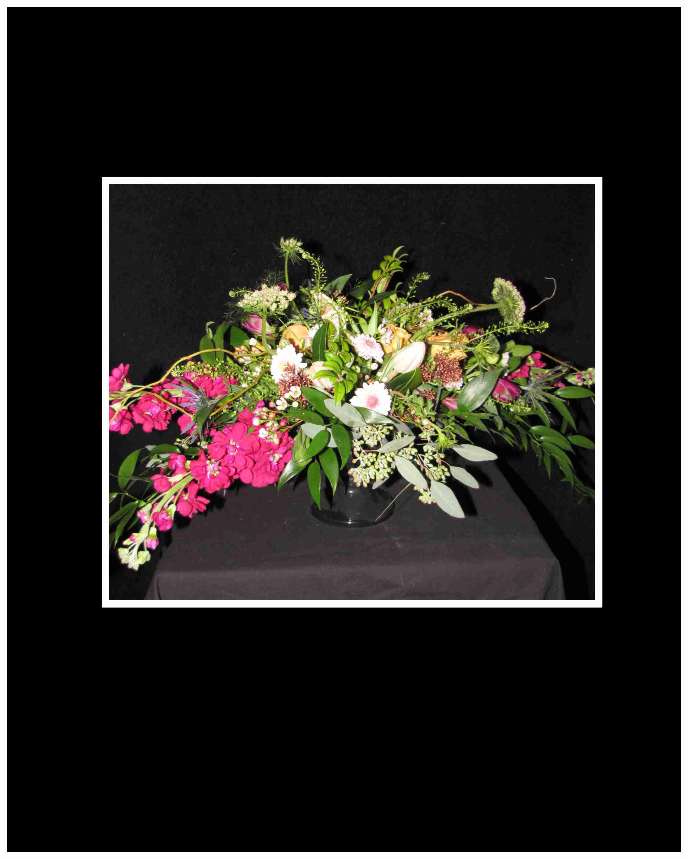 Large pink and white floral arrangement in a glass vase