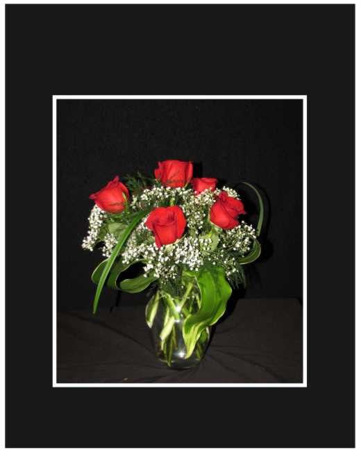 Red roses in a glass vase with baby's breath