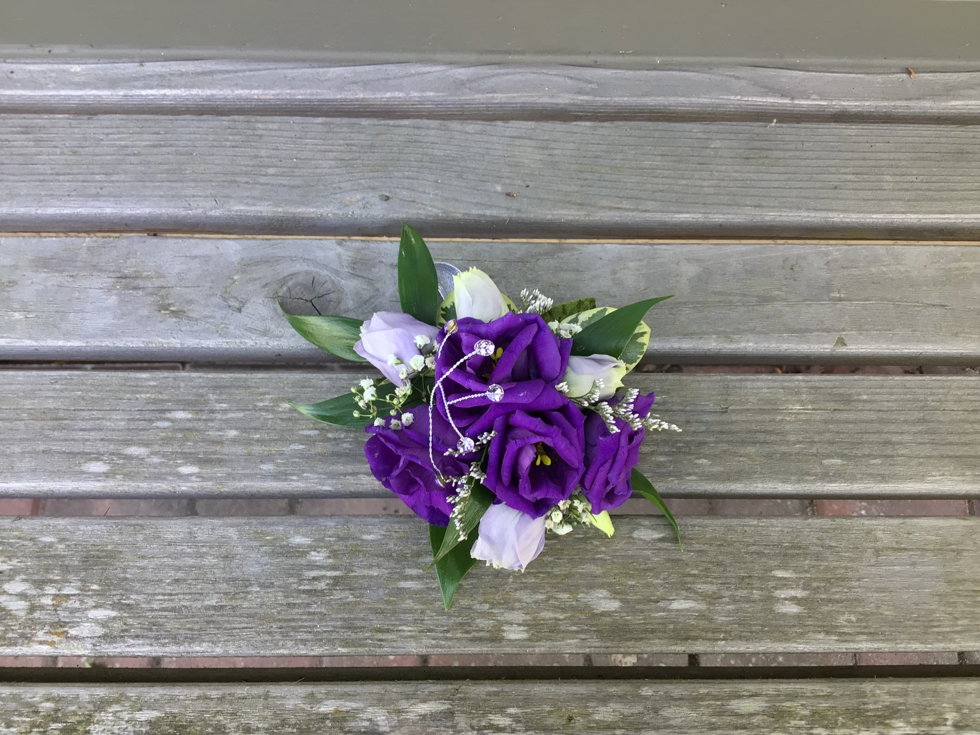 Small bouquet of purple and white flowers with greenery