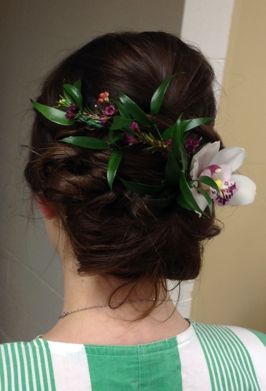 Floral hairpiece with white orchid blooms and purple accents in dark hair