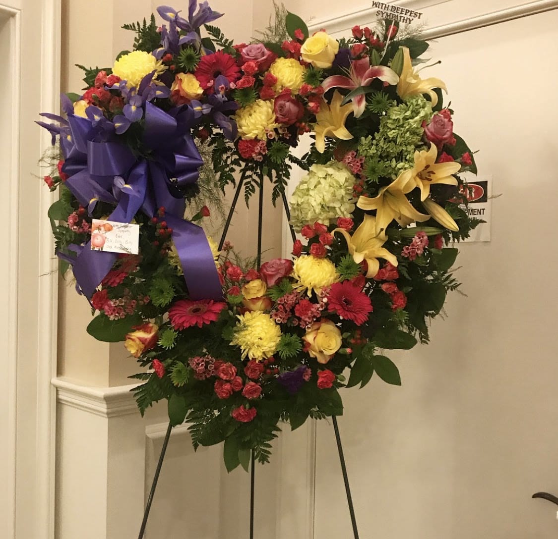 Large heart-shaped sympathy wreath with mixed flowers on an easel