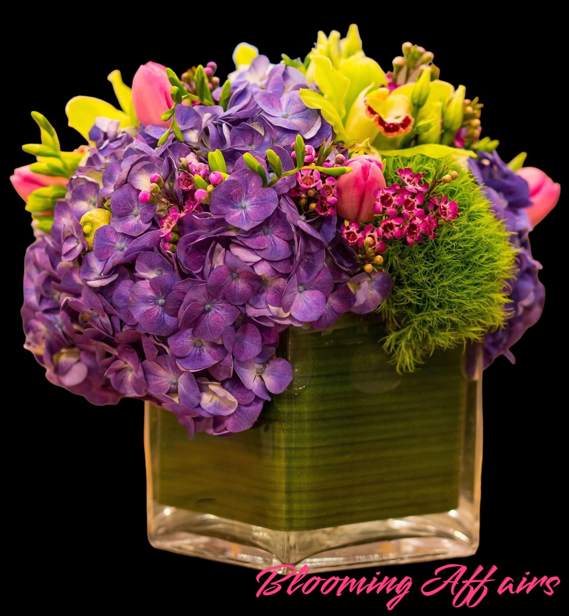 Purple hydrangeas and pink tulips in a square glass vase
