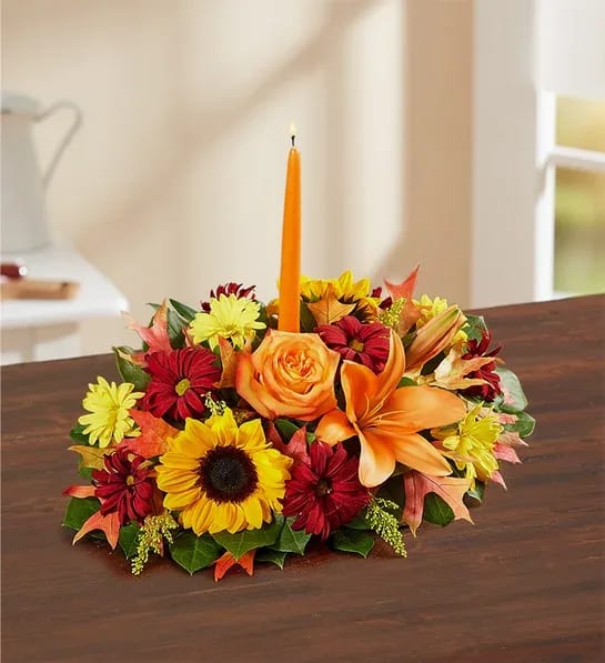 Autumn floral centerpiece with a tall orange candle