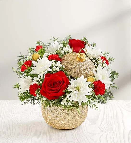 Red and white floral arrangement in a gold ornament-shaped vase