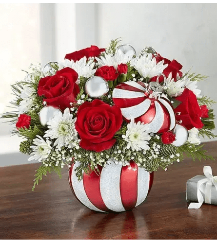 Sparkling peppermint Ornament - Arrangement of red roses and mini carnations; white cushion poms; accented with baby’s breath, assorted Christmas greens and decorative silver ornament balls Designed in a reusable Starlight Starbright Ornament featuring a satin red and glittering white finish and matching removable lid.