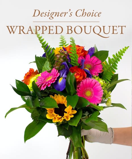 Wrapped bouquet of mixed bright flowers with greenery