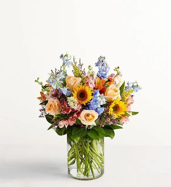 Spring Sensation - There’s so much to love about spring - but it’s the bright, beautiful blooms that make it truly sensational! Our stunning Spring Sensation bouquet features a garden-style mix of pink, blue, yellow, and peach blooms. Artistically hand-designed by our expert florists, it’s a luxurious arrangement that delivers the beauty of the season right to their door. All-around arrangement of fresh peach roses, orange and pink tulips, mini sunflowers, pink larkspur, blue delphinium, and more