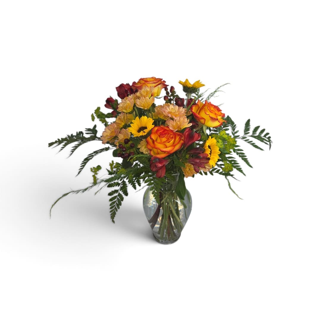 Mixed bouquet of orange roses and yellow flowers in a glass vase