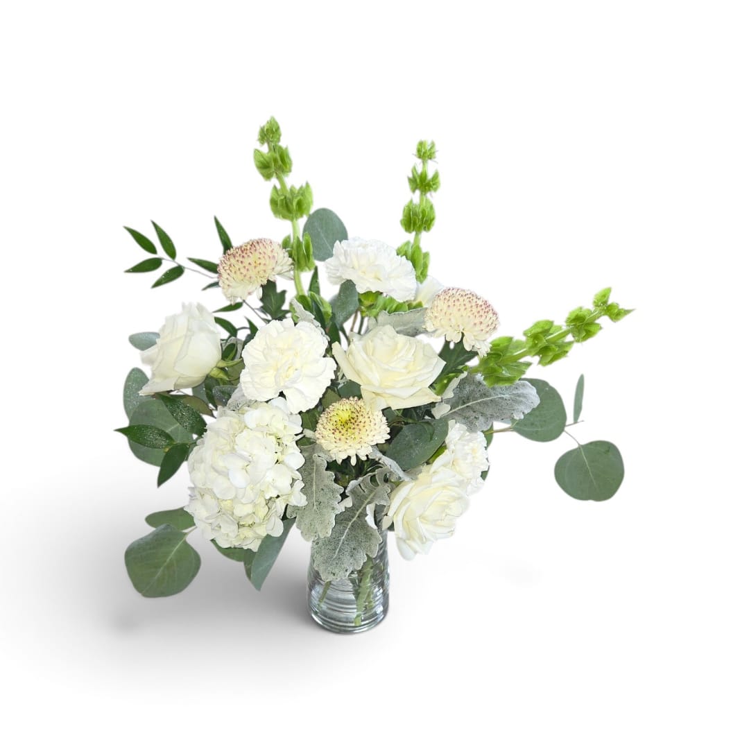 White roses and hydrangea in a clear glass vase with eucalyptus
