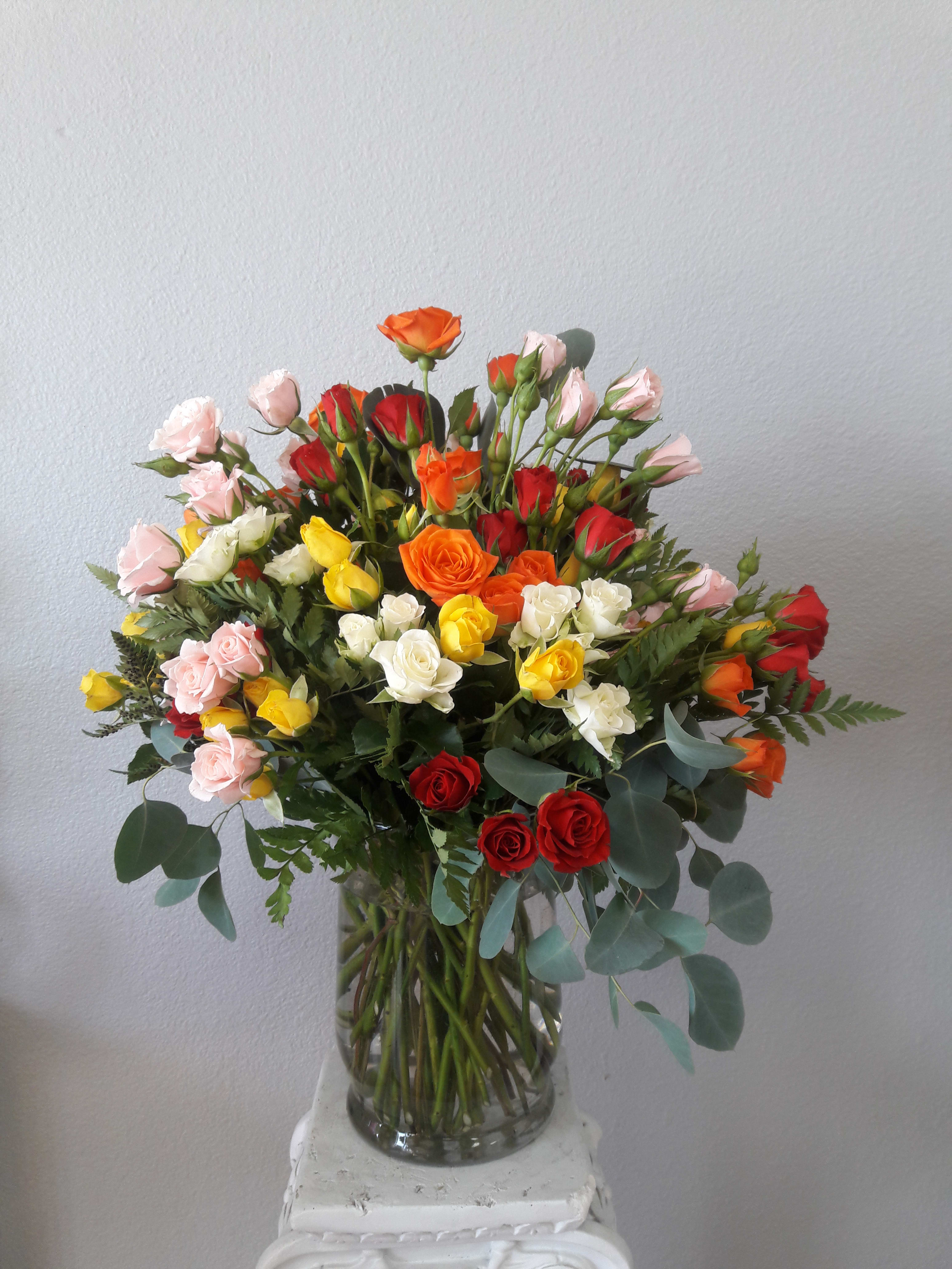 Mixed bouquet of roses in a clear glass vase