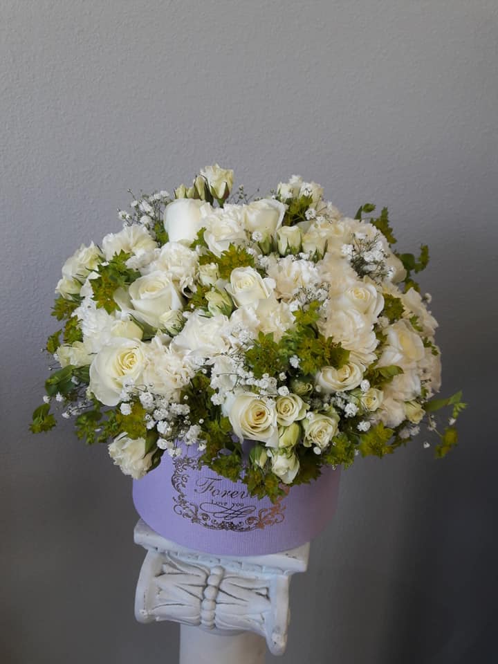 Amar's Field Of White - This lush Arrangement in a colored box includes roses, carnation and spray roses with greens. Can be sent for any occasion to brighten anyone's day. 