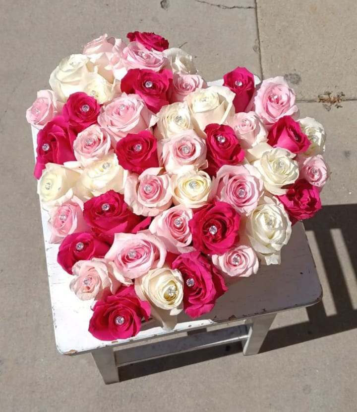 Heart-shaped bouquet of pink, white, and red roses