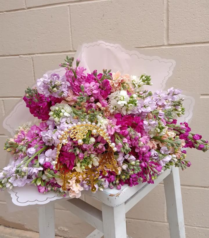 Large bouquet of pink, lavender, and white flowers with a gold handle
