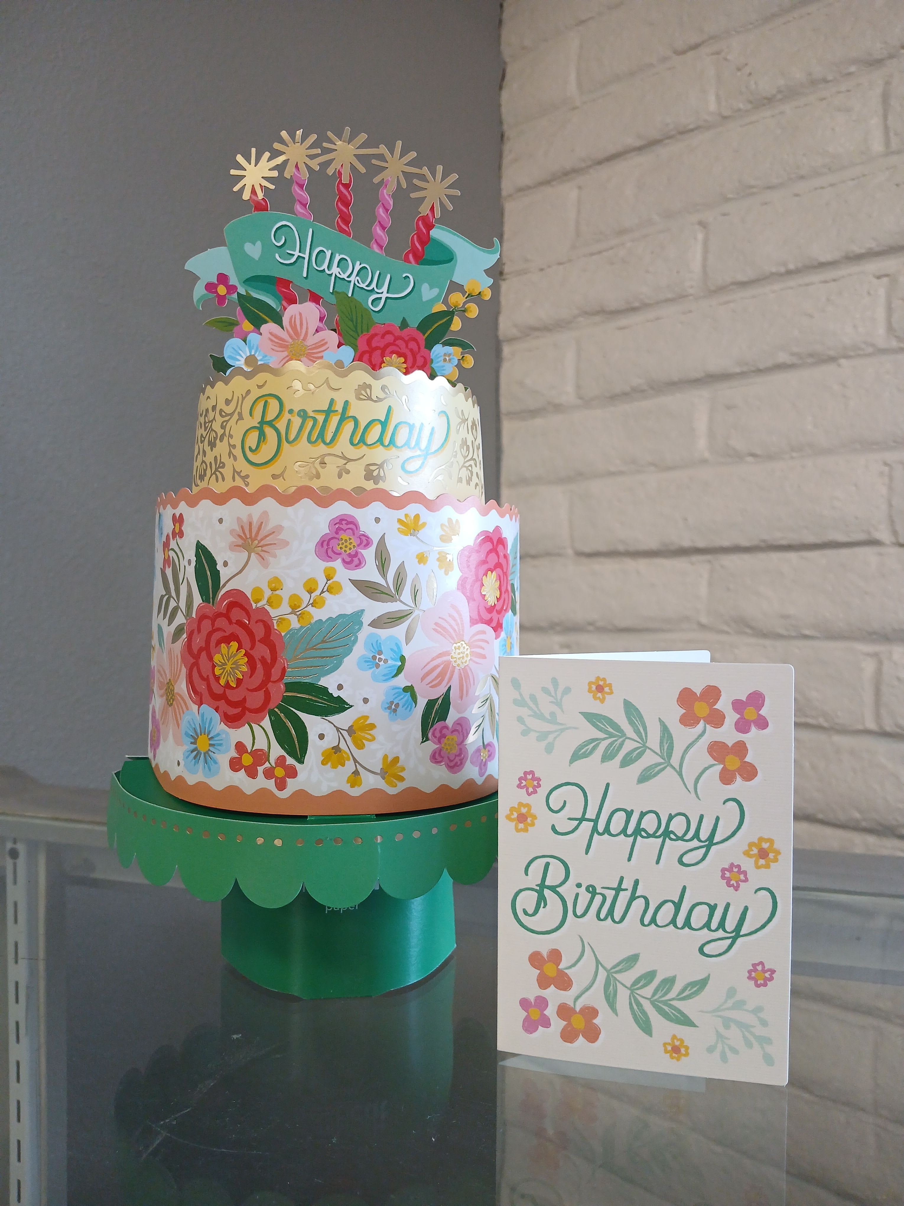 Bloomin cake  - Make their birthday unforgettable with our Blooming Birthday Cake! This stunning two-tiered masterpiece, adorned with shimmering gold foil and elegant floral details, is the perfect way to celebrate in style.