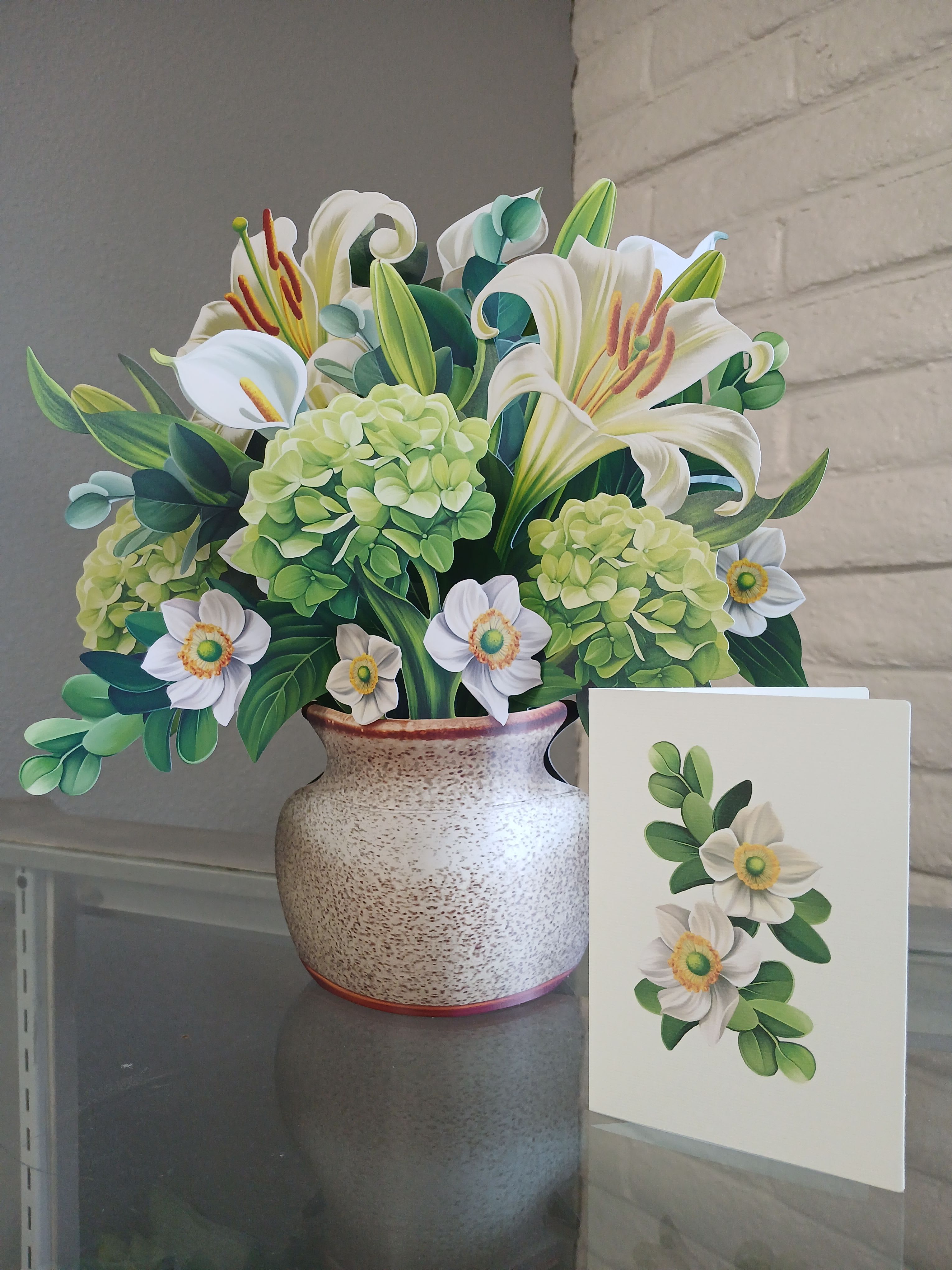 With Sympathy - This forever flower bouquet embodies serenity and grace in the form of crisp, white lilies and calla lilies, alongside sweet anemones, lush green hydrangeas