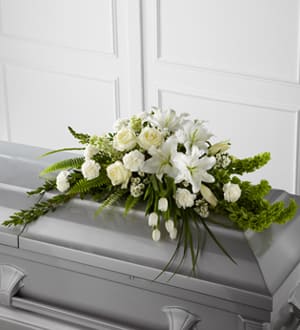 White floral spray on a gray casket