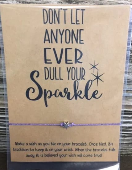 Card with the words "Don't let anyone ever dull your sparkle" and a purple bracelet