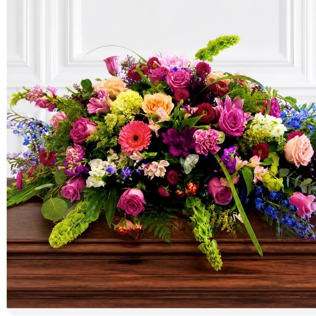 Large mixed flower arrangement in bright pink, peach, purple, and blue