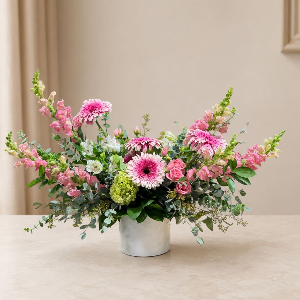 Pink and white mixed flower arrangement in a white vase