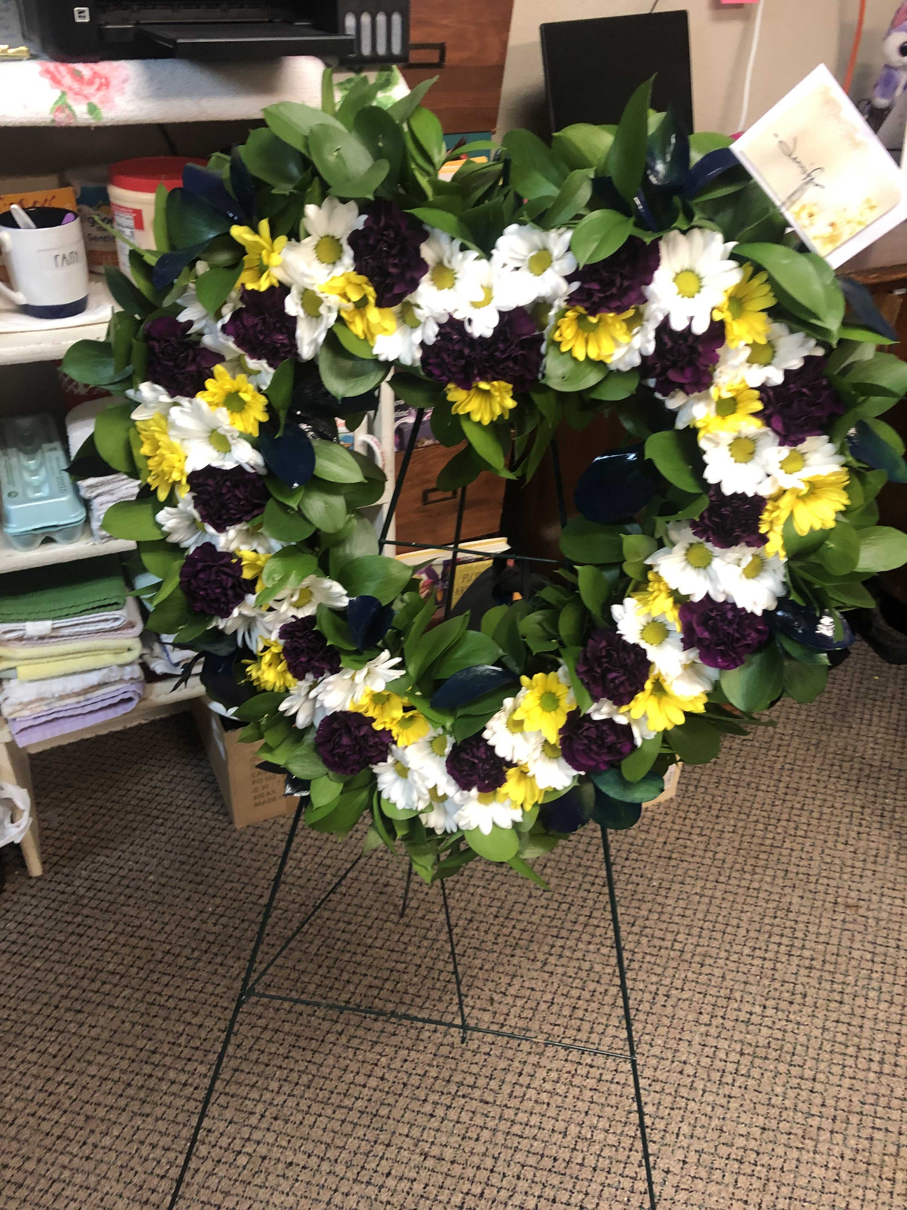 Heart-shaped floral wreath with white, yellow, and dark purple flowers
