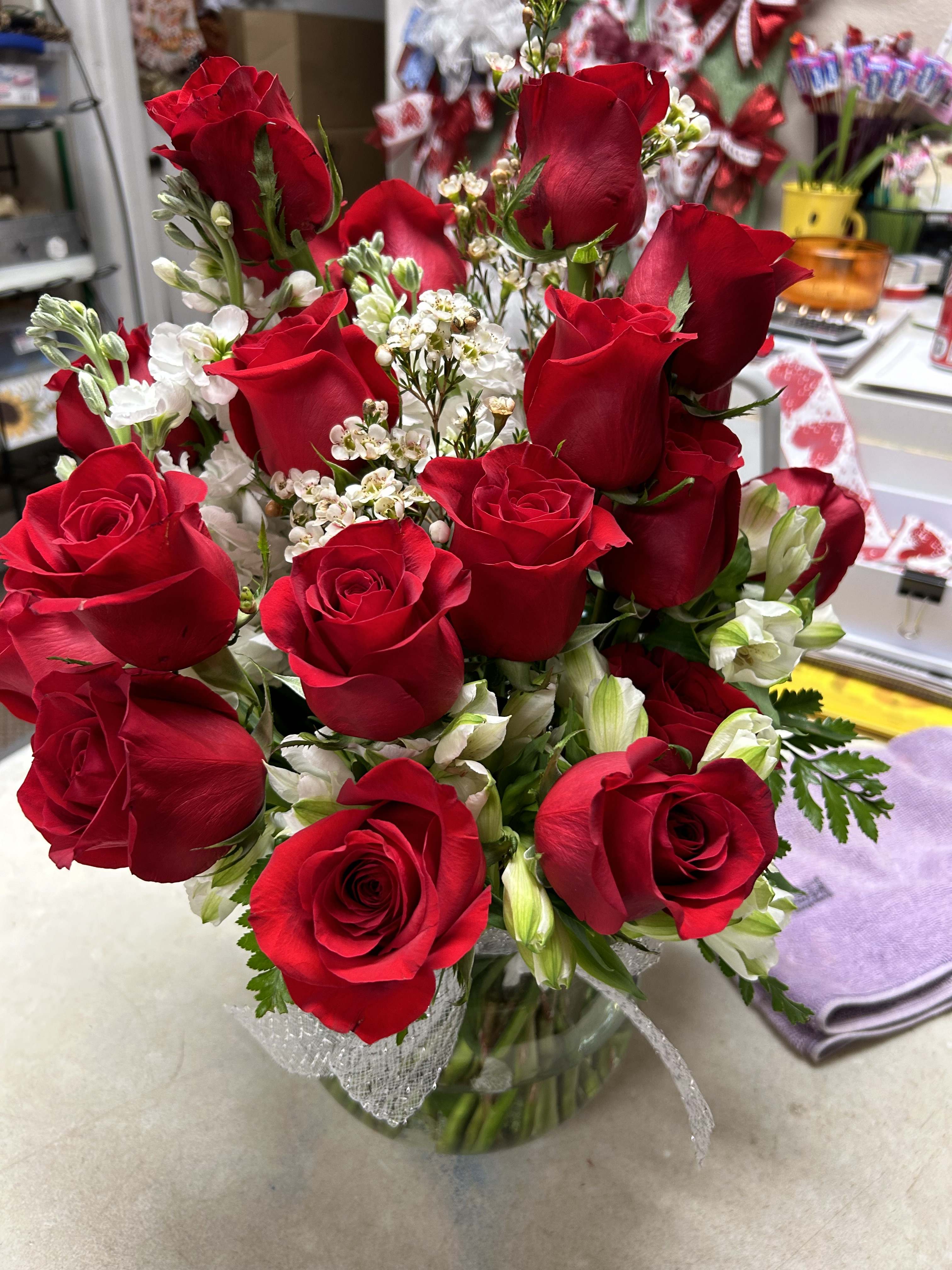 Bouquet of red roses with white filler flowers in a glass vase