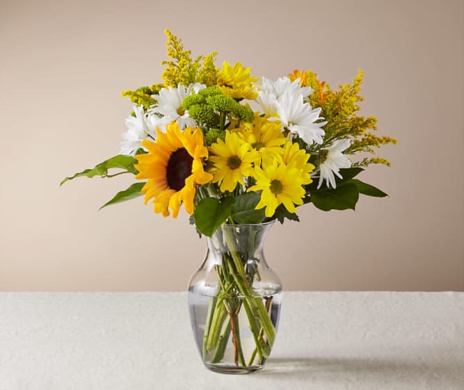 Yellow and white mixed bouquet in a clear glass vase