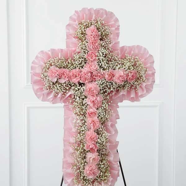 Pink floral cross-shaped standing spray with carnations and baby's breath
