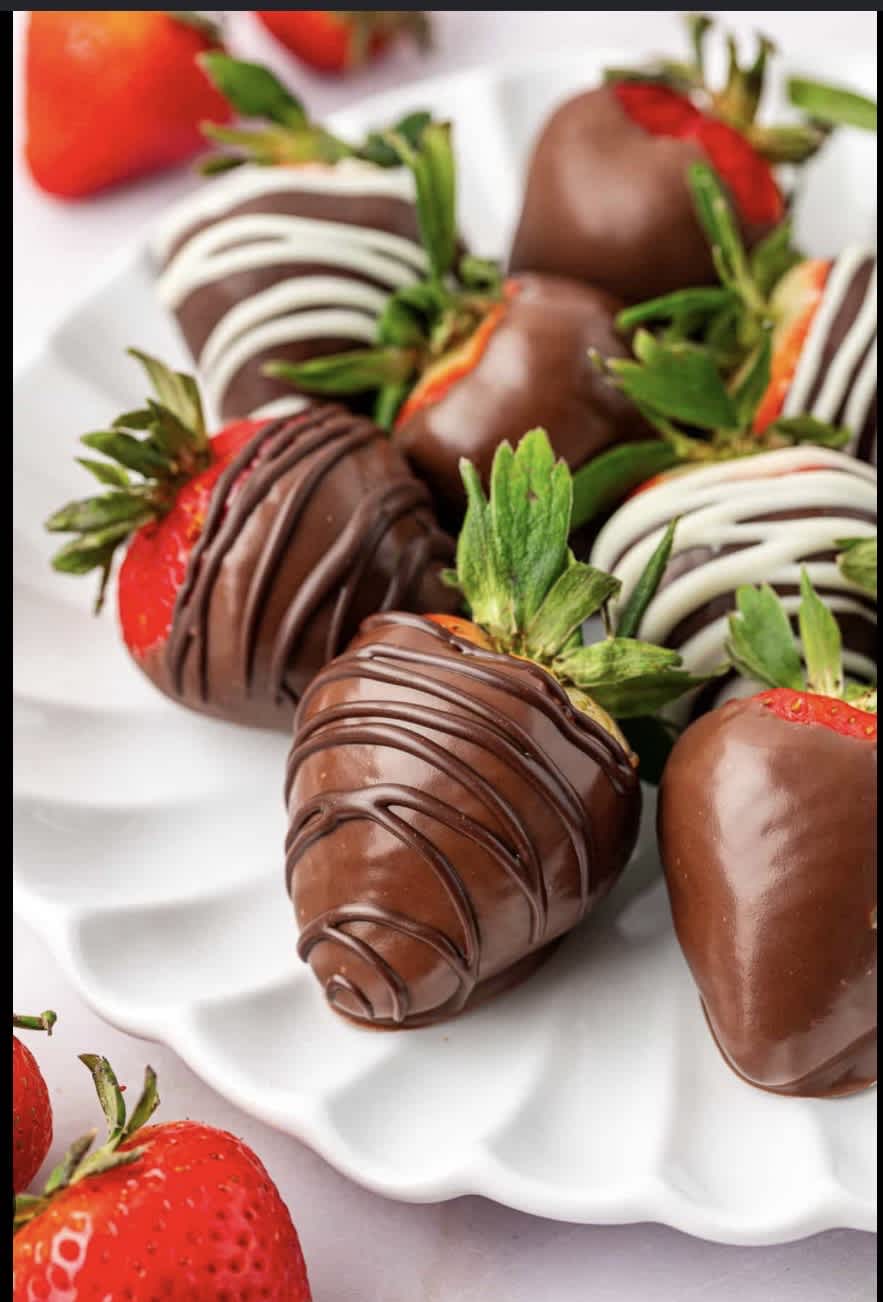 Chocolate-covered strawberries on a white serving plate