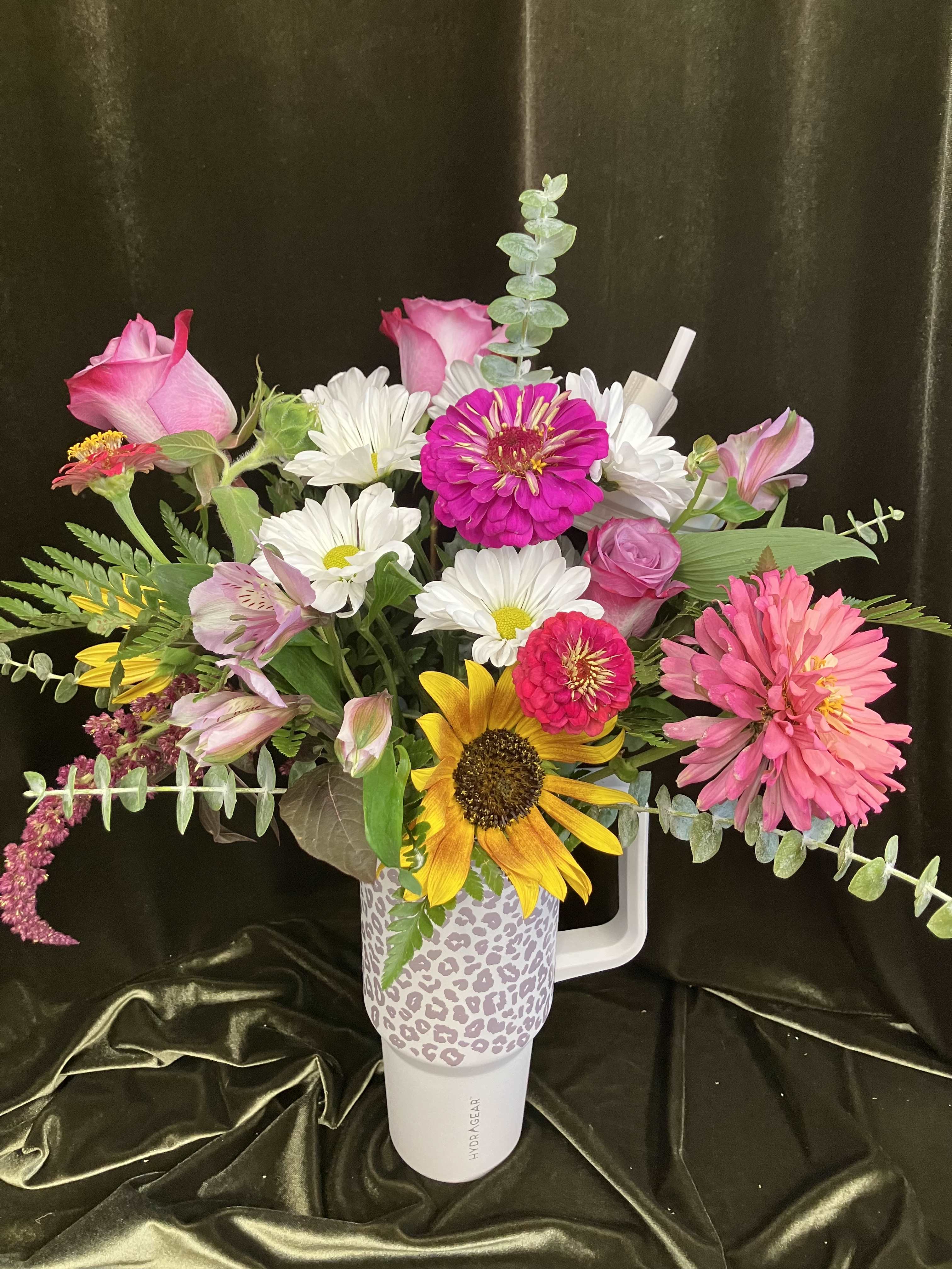 Mixed bouquet in a leopard-print tumbler with pink, white, and yellow flowers