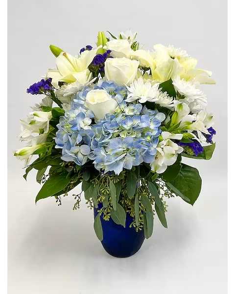 Beautiful in Blue - Make a lasting impression with In Bloom Flowers' "Beautiful in Blue" flower arrangement. Fresh hydrangea, alstroemeria, lily, statice and cremones are elegantly arranged amongst greenery in a traditional blue bouquet vase. 