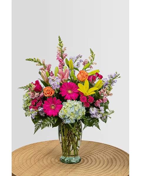  Spring Blooms  - The Spring Blooms features hydrangea, lilies, roses, spray roses, gerbera daisies, snapdragons and stock, arranged in a tall glass vase.  Occasional substitutions of equal or greater value of flowers, colors, or vases may occur due to supply limitations.