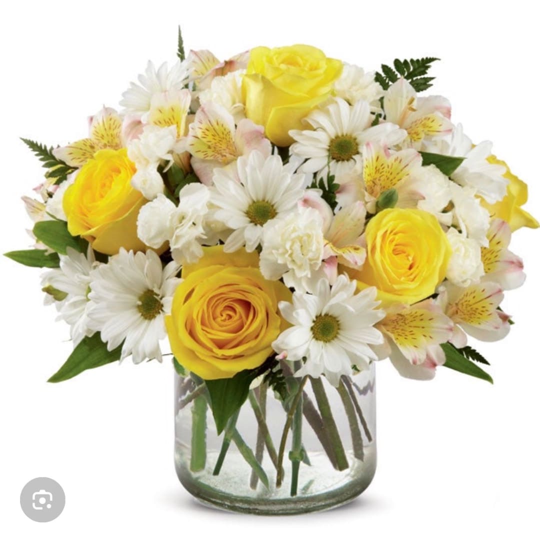 Yellow roses and white daisies in a clear glass vase