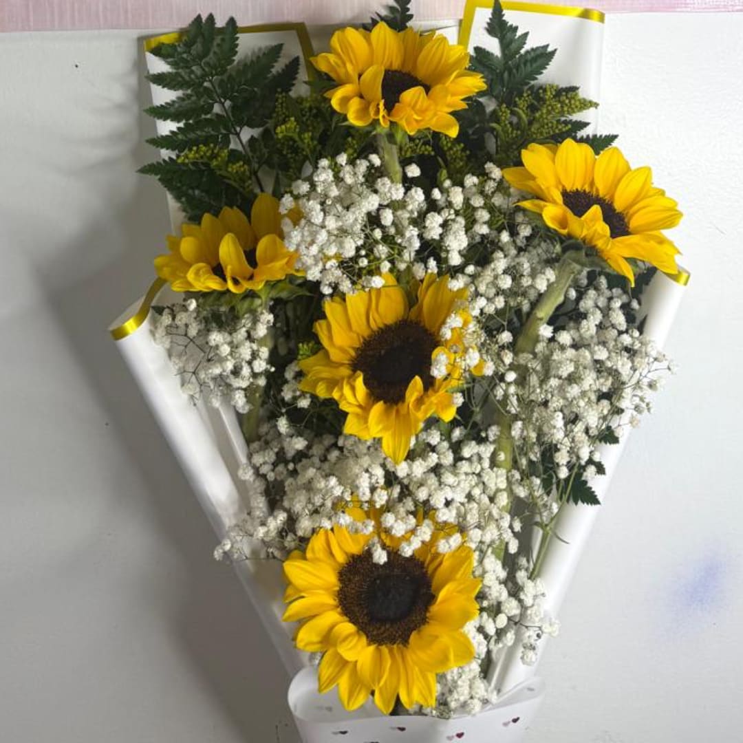Bouquet of yellow sunflowers with white baby's breath in white wrap