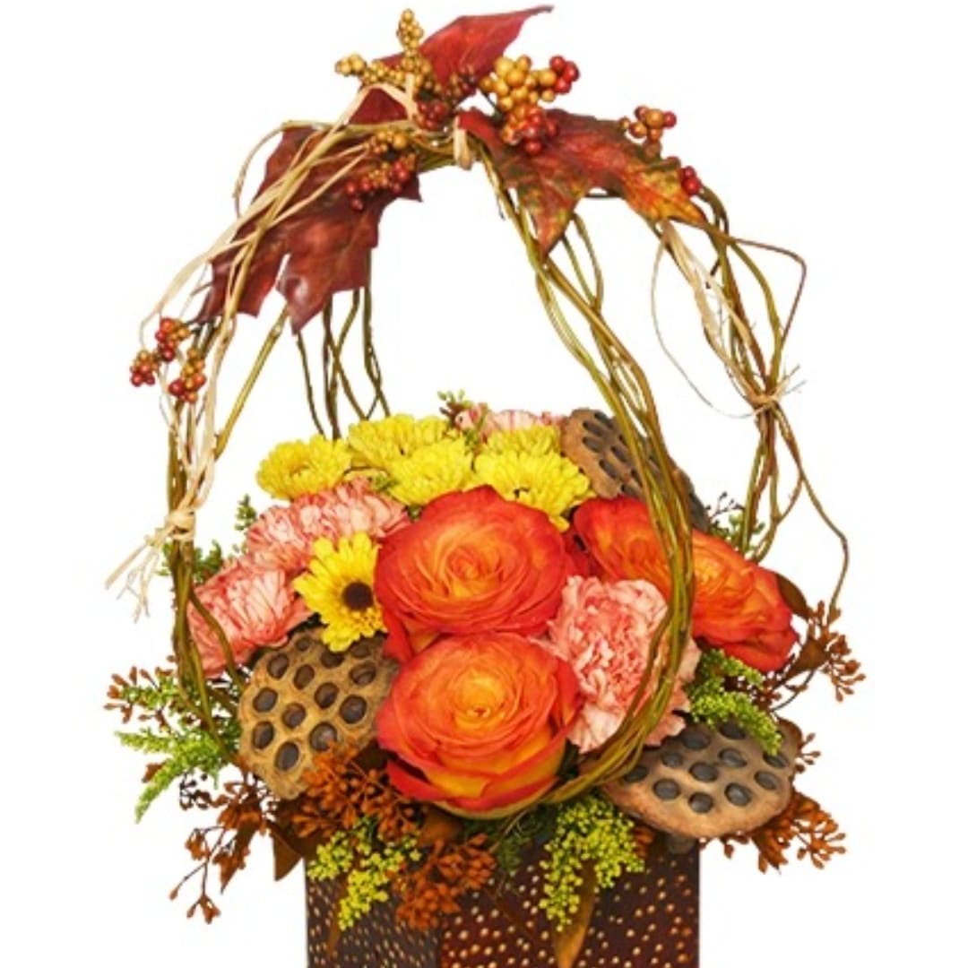 Autumn floral basket with orange roses, yellow mums, and dried leaves