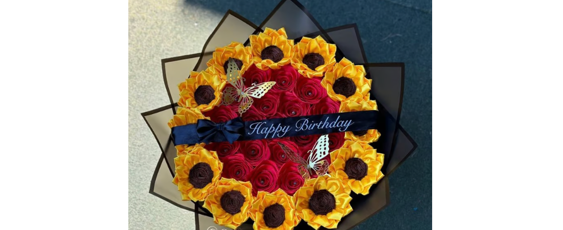 Round bouquet of red and yellow flowers with a Happy Birthday ribbon