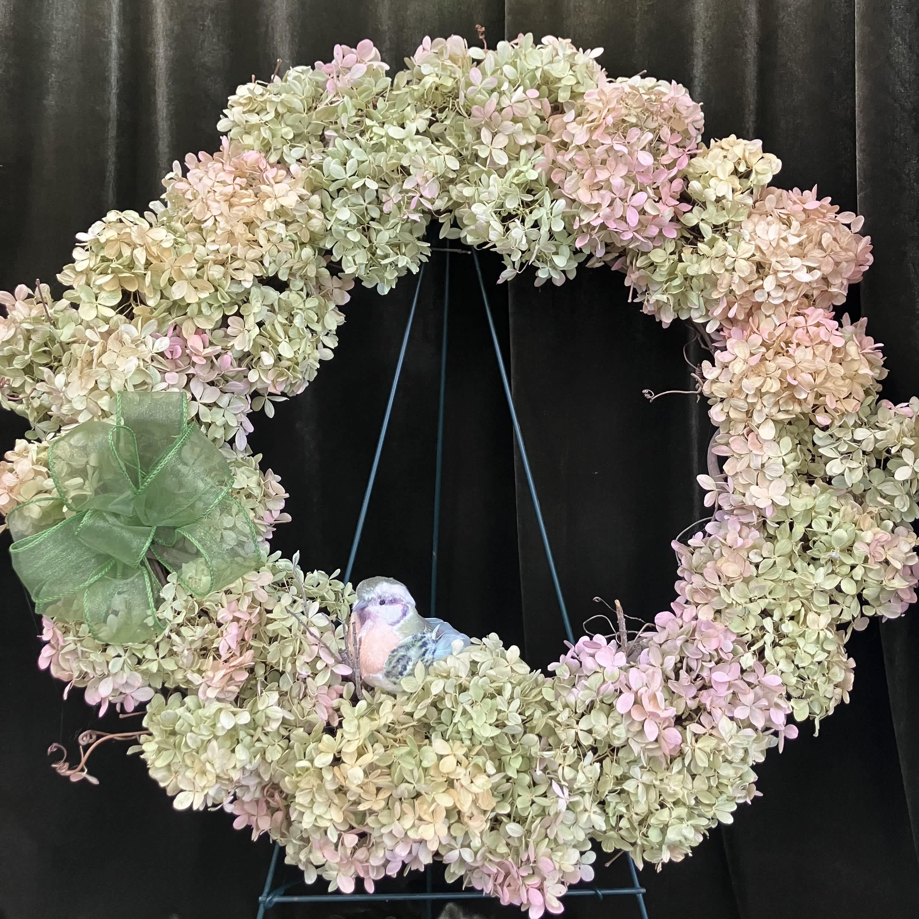 Pastel hydrangea wreath with a green bow and small bird ornament