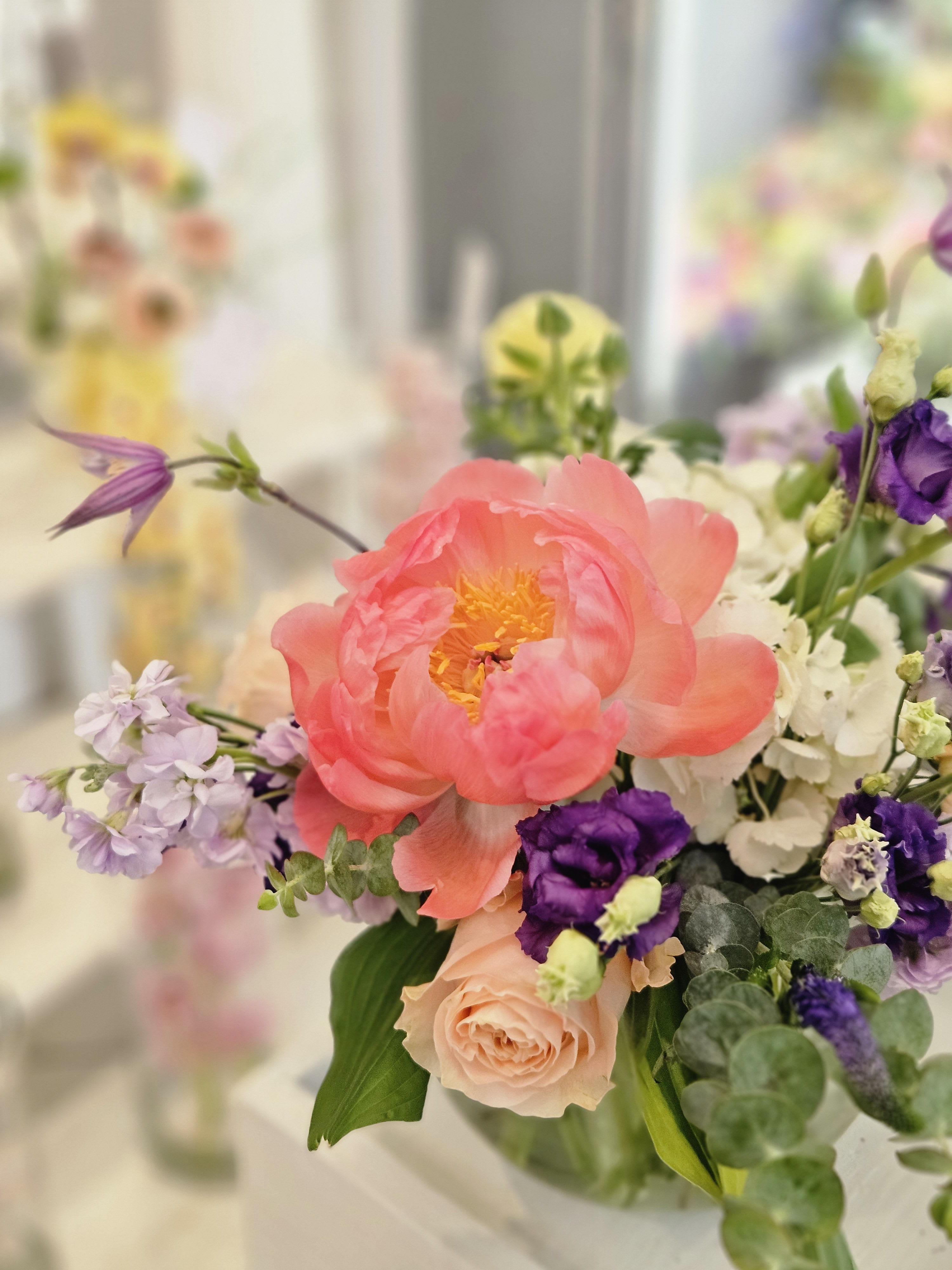 Pink peony bouquet with purple and white flowers in a vase