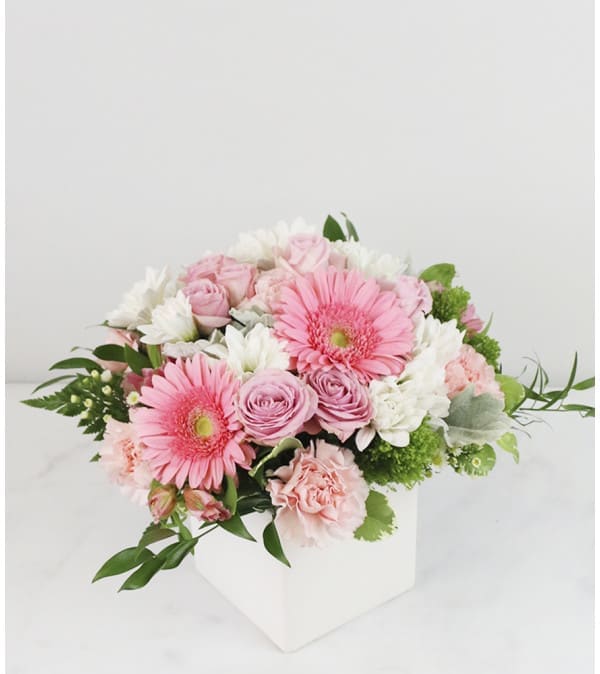 Pink and white bouquet in a white box vase